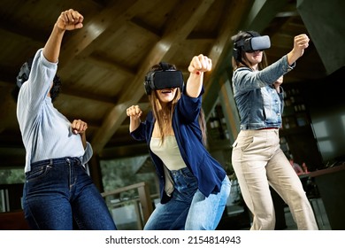 Group Of Young Women Using Virtual Reality Headset - Girlfriends Playing Ninja Fight Video Games In Meta Verse Space With Futuristic Goggles Having Fun Together