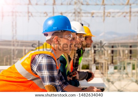 Group of young workers looking ahead in electric power station