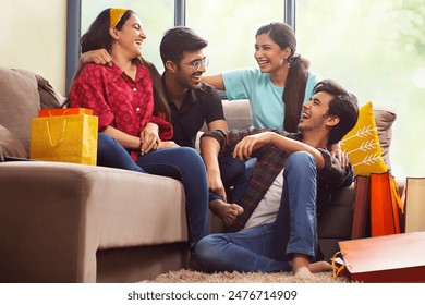 A Group of youngsters talking happily in living room after a shopping spree.