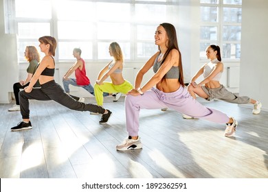 Group Of Youth Stretching Legs Before Dance Class, Exercising, Going To Learn Hip-hop Moves. In Studio