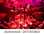 Groupe hookahs stand on the table in a club restaurant on the party. Friends party in hookah lounge, bar. Smoking shisha, relax shisha party concept. 