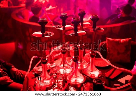 Groupe hookahs stand on the table in a club restaurant on the party. Friends party in hookah lounge, bar. Smoking shisha, relax shisha party concept. 