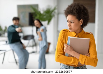 Groupmates bullying and laughing at sad black young lady in university hallway, upset and stressed african american female student bullied by classmates in college - Powered by Shutterstock