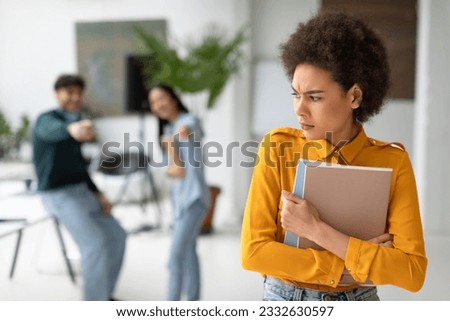 Groupmates bullying and laughing at sad black young lady in university hallway, upset and stressed african american female student bullied by classmates in college
