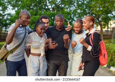Groups of african friends, students or sport lovers consisting of male and female individuals, happily staring into the smart phone with various jubilation gestures and expressions