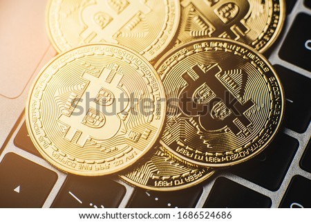 Groups of bitcoin is place on the keyboard of the laptop. Online payment technology, digital wallet, computer financial,  cryptocurrency trading and investment concept.