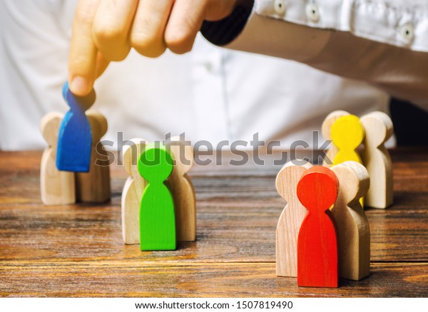 Groups of multicolored wooden people and\
businessman. The concept of market segmentation. Target audience,\
customer care. Market group of buyers. Customer relationship\
management. Selective\
focus