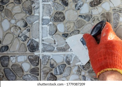 Grouting Decorative Floor Tiles With White Cement Grout. Close Up.