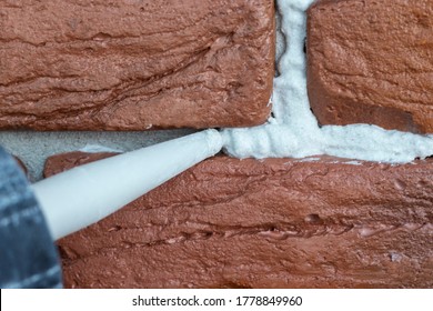 Grouting Decorative Gypsum Brick With White Cement Grout. Applying Grout With A Syringe.