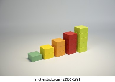 growing financial chart with five bars of different colors. growth chart from wooden cubes. Economic growth, increase or success theme.
