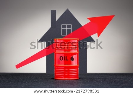 Growing oil prices concept. Barrel with heating fuel on the background of house. 