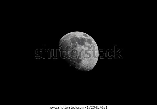 Growing phase moon in the dark\
sky