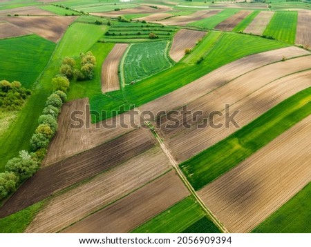 Similar – Aerial view of lush green rice field with small winding canal. Sustainable agriculture landscape. Sustainable rice farming. Rice cultivation. Green landscape. Organic farming. Sustainable land use.