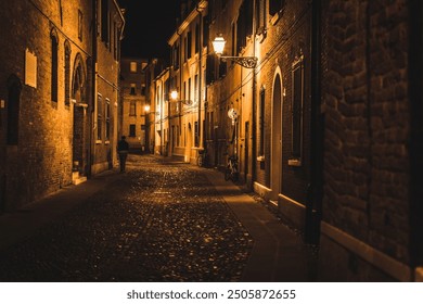 A grown man walks alone at night in a lonely alley of an ancient city - Powered by Shutterstock