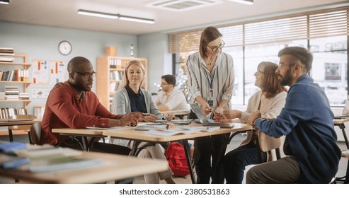 Grown Up Men and Women Working in Groups for an Assignment in Specialty Development Center. Adult Classmates Working on a Team Assignment, Young Female Teacher Explaining the Exercise Goals