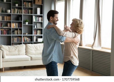 Grown Up Son Came To Visit Elderly Mom, Adult Child And Senior Mum Standing In Living Room Dancing Waltz, People Enjoy Warm Communication Having Fun Indoor, Life Value, Time With Aged Parents Concept