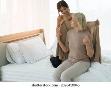 Grown-up daughter Take care adopted mother elderly Caucasian at home. Young women nurses helping to service senior retire at nursing home. Concept love family mother-daughter-in-law adoption