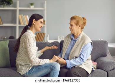 Grown-up daughter talking to senior mother. Happy daughter and friendly mother-in-law sitting on sofa and having sincere honest conversation. Mutual understanding, family supporting each other concept