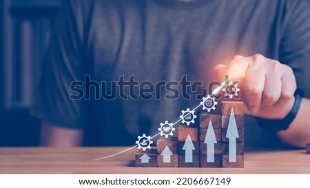 Growth arrow with wood block step up, showing business icon, human, partner investment, Growth chart, target and high profit. Business improvement concept. Man looking mobile phone on background.