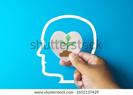 Growth mindset and personal development concept.A small tree growing in a heart shape being placed into a brain,representing positive thinking,self-improvement,developing new skills.