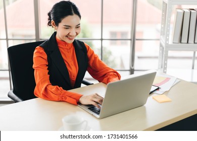 Growth Mindset And Work With Passion Concept. Business Asian Woman Work With Happy Smile And Concentration To Job. Modern Workplace With Technology And Window Light