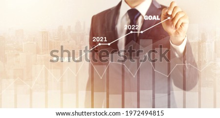 Growth success developments in 2021, 2022 to 2023 concept. Businessman in suit forecast analysis plan profit chart with pen and increase of positive indicators. graph business financial plan year.