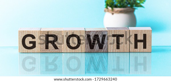 GROWTH word\
from wooden blocks with letters, to divide or use something with\
others share concept, blue\
background