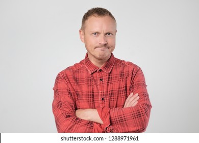 Grumpy Mature European Man Posing In Studio With Arms Folded