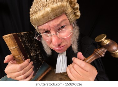 Grumpy old judge in extreme wide angle closeup with hammer and wig