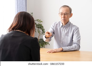 Grumpy Senior Asian Man Talking In Living Room