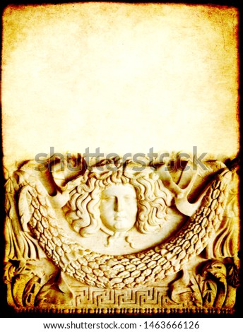 Grunge background with paper texture and detail of an ancient carved stone ornament with Medusa Gorgon head. Copy space for text. Mock up template