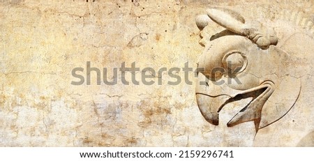 Grunge background with stone texture and bas-relief of head of griffin. Horizontal banner with ancient griffin statue in Persepolis, Iran. Copy space for text. Mock up template 