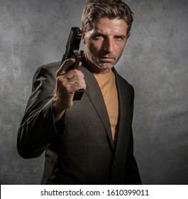 Grunge Cinematic Portrait Of Attractive And Dangerous Looking Mafia Hitman Or Secret Service Especial Agent Man In Blazer Pointing Gun In Crime Mob And Criminal Lifestyle Concept