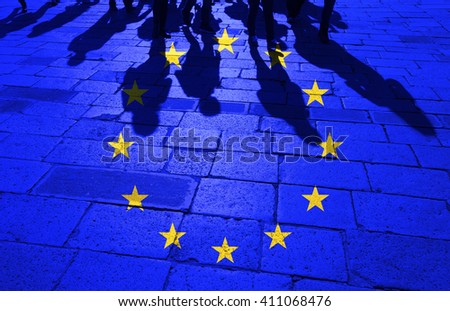 Grunge European Union flag with shadows of the crowd of walking people on stone tiled street floor.