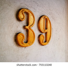 Grunge Golden Metal Of Number Of Street Adress With Number Closeup.