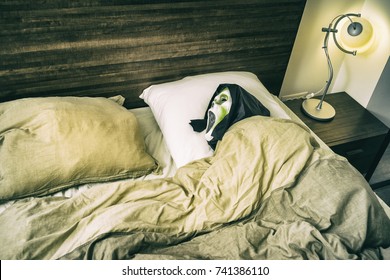 Grunge Halloween Scary Scene/Zombie Entity Tucked In The Bed With Open Mouth And Black Hood Waiting To Scare Someone As A Prank.