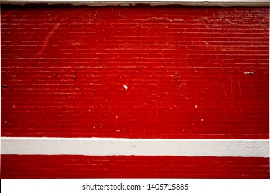 a grunge red repainted brick wall in Bushwick Brooklyn near Montrose station .