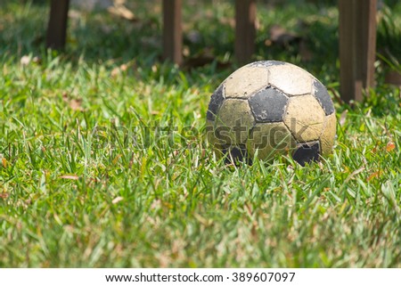 Grunge soccer ball, football in the lawn, very old football of poor kids