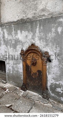 Grunge Texture. Rusty Antique Outdoor Spigot. Rusty drinking water tap in the yard of the house. Сoncrete wall. Warsaw courtyard