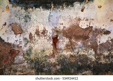 Grunge Wall Texture Background. Paint Cracking Off Dark Wall With Rust Underneath.