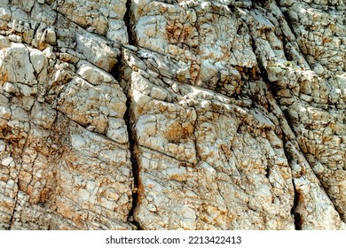 Grungy cragged bumpy pitted cavity stone facade, split layer gap.Ruined cracked shattered worn rough hiking canyon.Old ragged grunge steep marble cliff. Grand vintage crannied damaged impressive gorge - Powered by Shutterstock