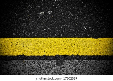 grungy, dirty view of asphalt with distinct yellow stripe