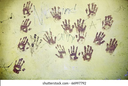 Grungy Image Of Muddy Hand Print Graffiti On A Rustic Wall.