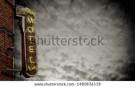 A Grungy Old Neon Motel Sign Against A Stormy Sky With Copy Space