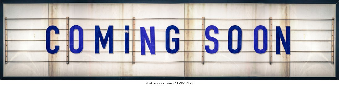 A Grungy Old Weathered Coming Soon Marquee Sign With Blue Letters