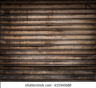 Grungy Weathered Metallic Roll Up Door. Rusty Iron Gate.