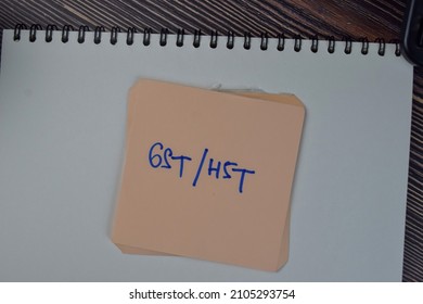 GST Or HST Write On Sticky Notes Isolated On Wooden Table.