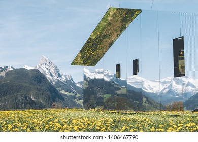 GSTAAD - MAY 23, 2019: The Swiss Alps Reflected On Mirage Gstaad By Doug Aitken