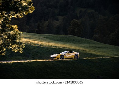Gstaad, Switzerland - September 2020: Ferrari F12 TDF (Tour De France) Yellow Italian Supercar Driving On Rural Mountain Roads In Gstaad During Supercar Owners Circle Annual Meeting