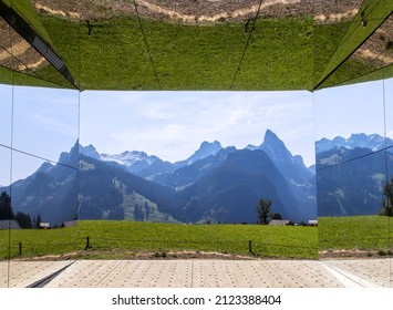 Gstaad, Switzerland - September 30, 2020: The Swiss Alps Landscape Reflected On Mirage Gstaad By Doug Aitken